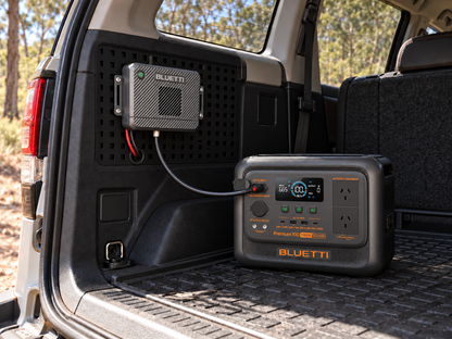Rendered lifestyle illustration of BLUETTI Premium 100 V2 and side-mounted Charger 2 in a vehicle; illustrative installation.
